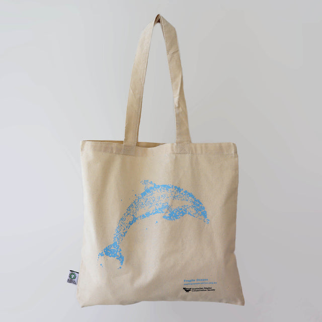 The Fragile Oceans organic cotton, natural-coloured tote bag with artwork of a dolphin by Collider, printed in blue.