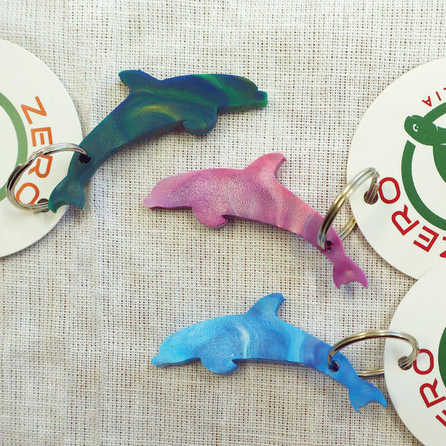 Purple, blue and green dolphin shaped keyrings made with recycled plastic milk bottle lids.