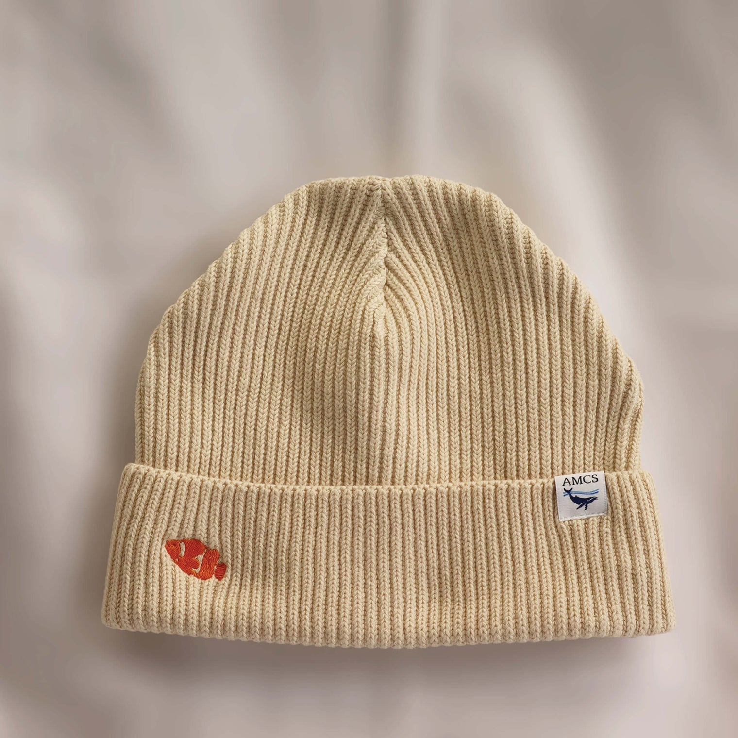 Ocean Icons organic cotton, beige beanie embroidered with a clownfish in orange thread.