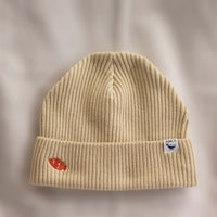 Ocean Icons organic cotton, beige beanie embroidered with a clownfish in orange thread.