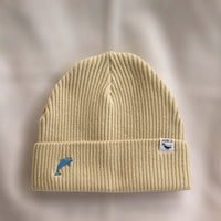 Ocean Icons organic cotton, beige beanie embroidered with a dolphin in blue thread.