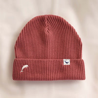 Ocean Icons organic cotton, clay beanie embroidered with a dolphin in white thread.