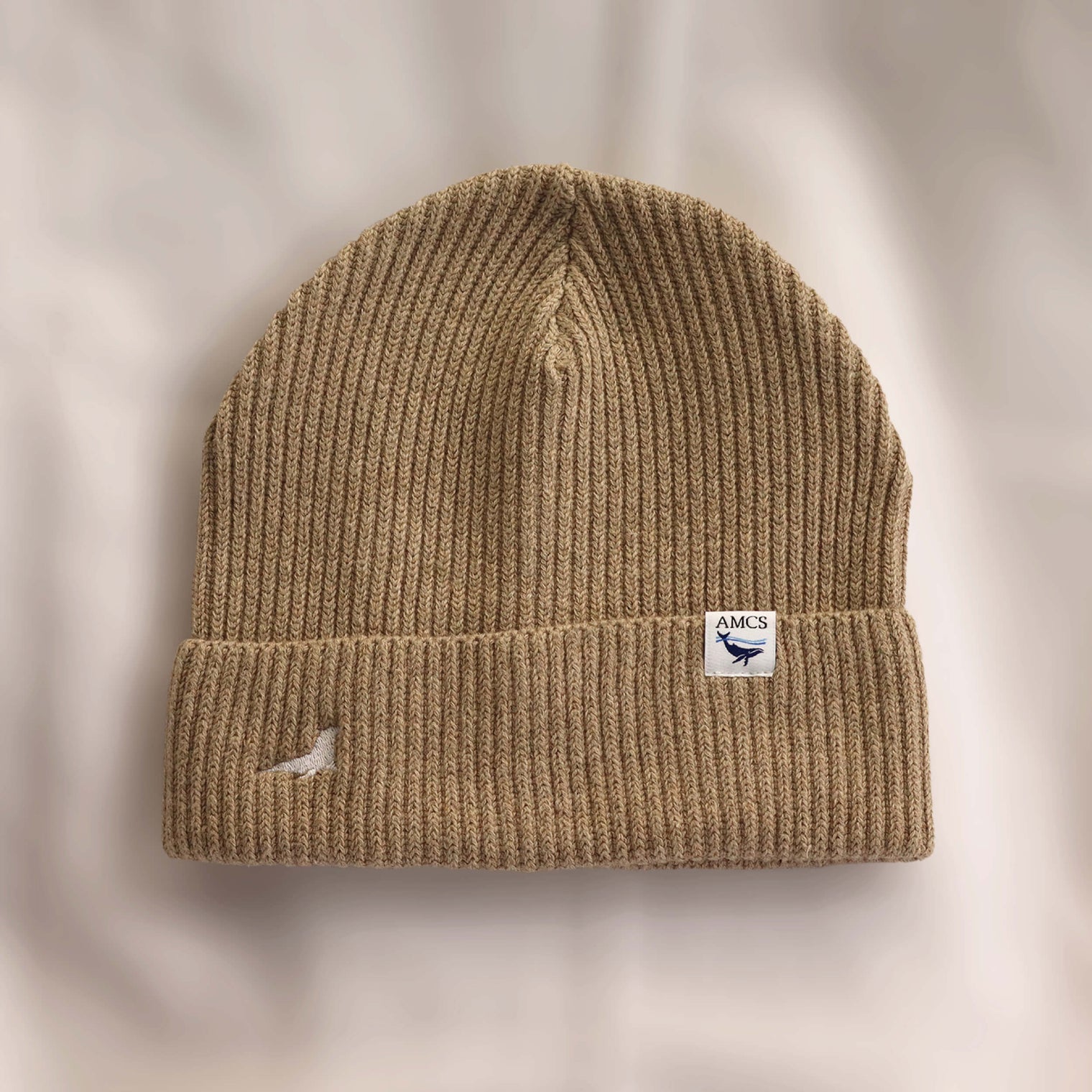 Ocean Icons organic cotton, sand beanie embroidered with a seal in white thread.