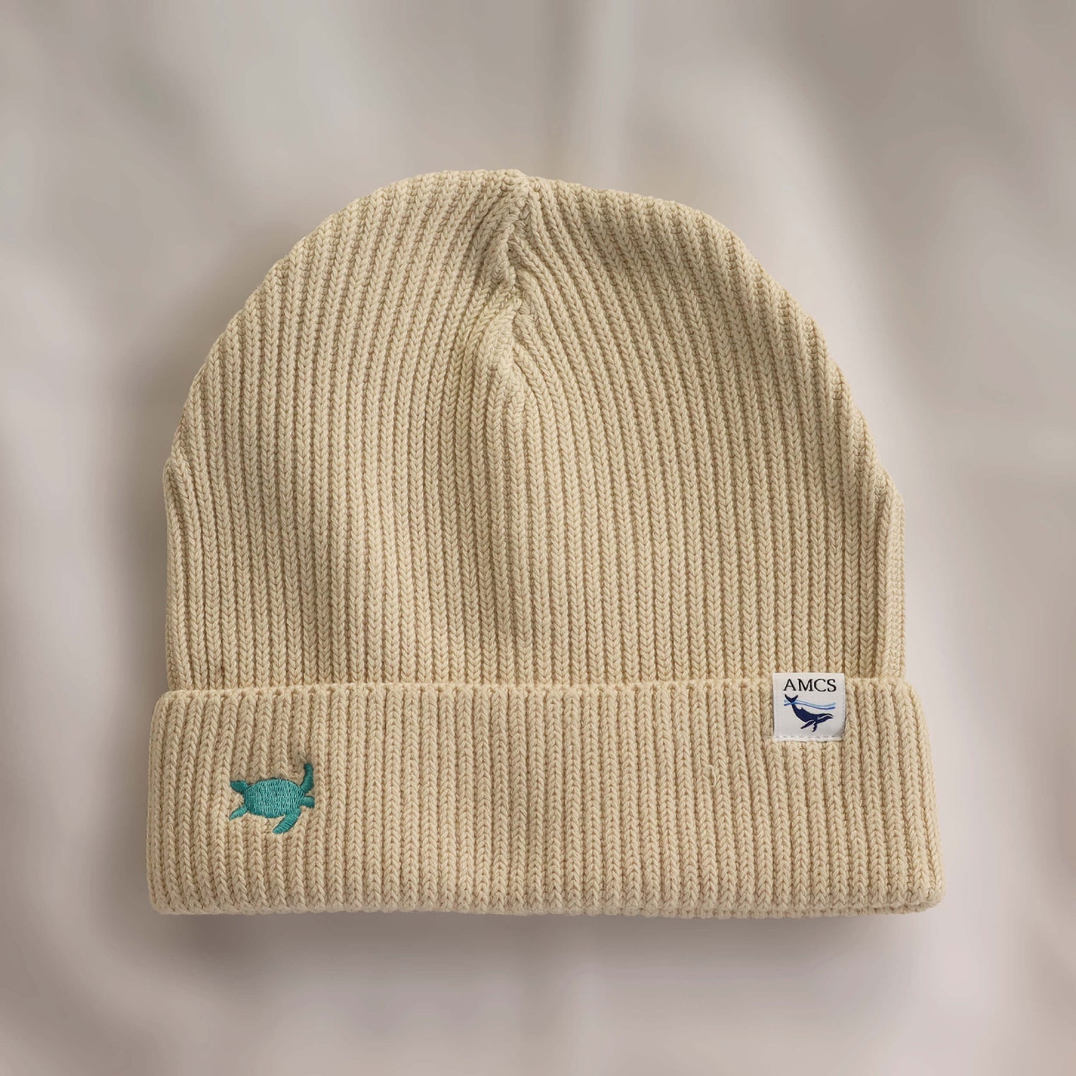 Ocean Icons organic cotton, beige beanie embroidered with a turtle in green thread.