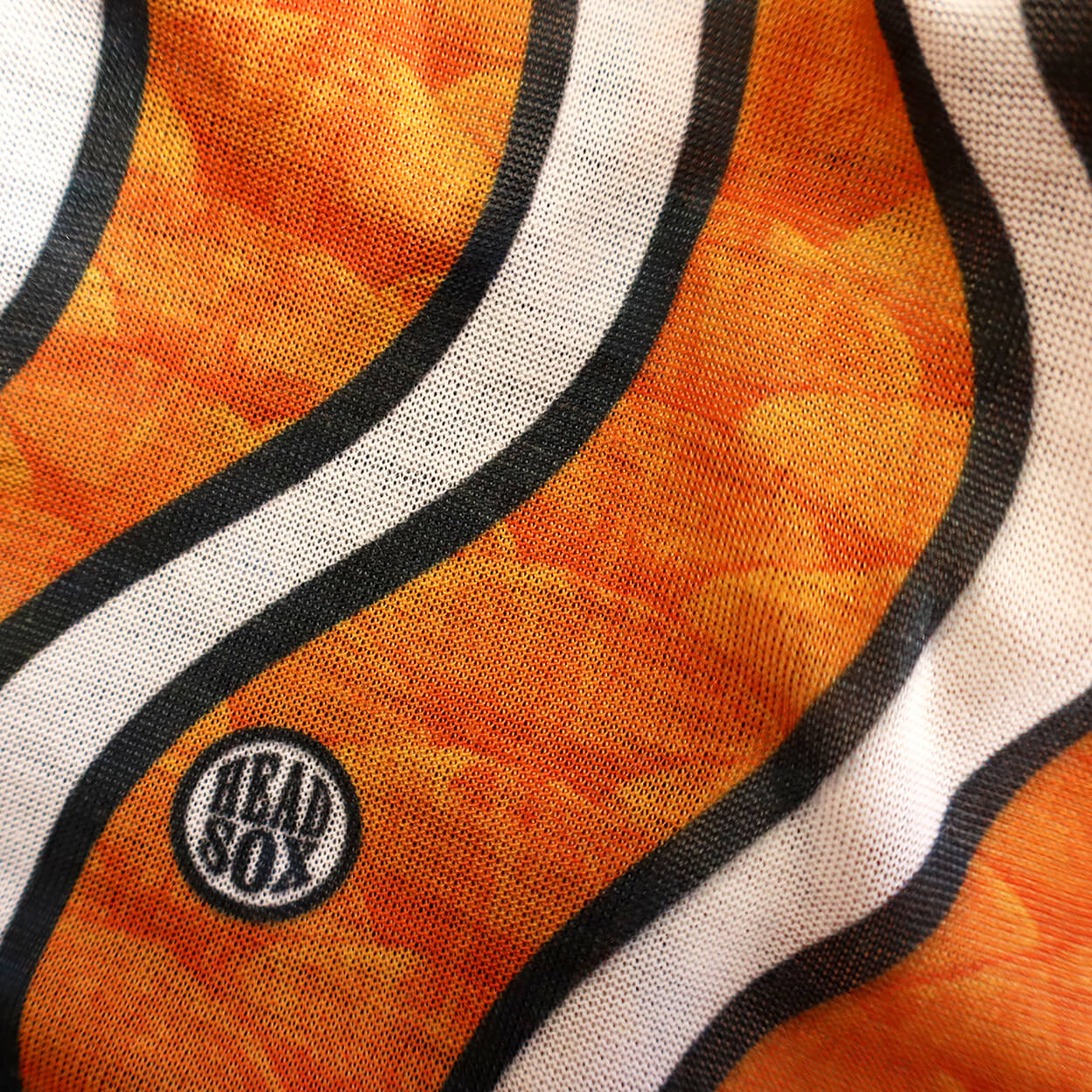 Close-up of the 'Ocean Life' buff fabric by Headsox in the multicoloured 'Clownfish’ design.