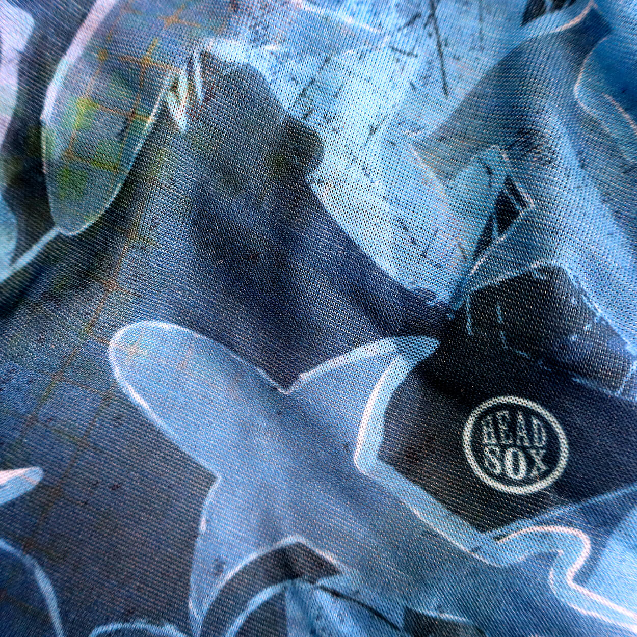 Close-up of the 'Ocean Life' buff fabric by Headsox in the multicoloured 'Shark Camouflage’ design.