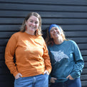 AMCS team wearing Fragile Oceans organic cotton, long sleeve, orange t-shirt with seal print and teal t-shirt with manta ray print.