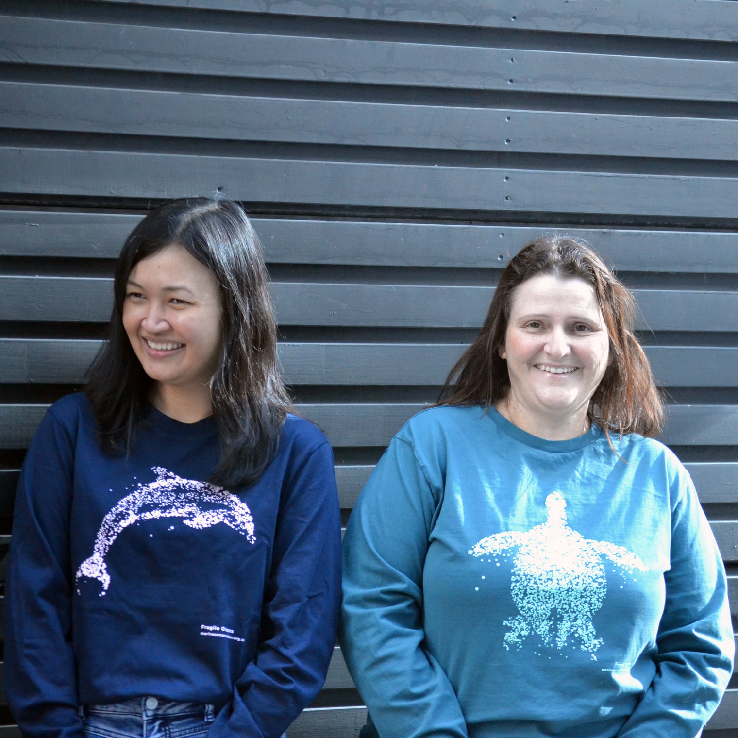 AMCS team wearing Fragile Oceans organic cotton, long sleeve, navy t-shirt with dolphin print and teal t-shirt with turtle print.