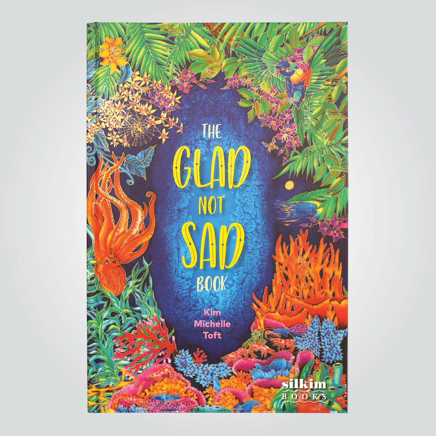'The Glad Not Sad Book' cover by Kim Michelle Toft, featuring a vibrant illustration of the colourful coral, flora and wildlife.