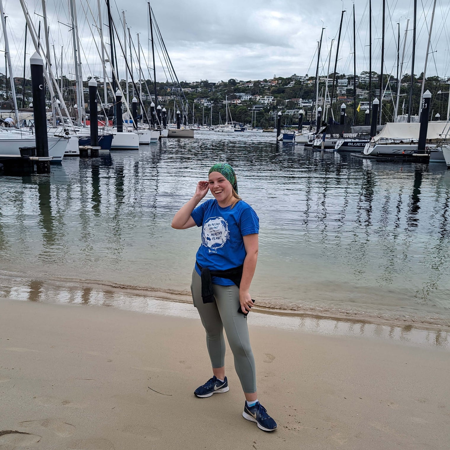AMCS team member wearing Headsox buff with a boat marina and yachts in the background.