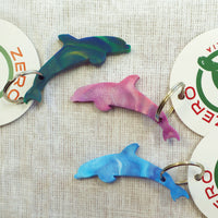 Purple, blue and green dolphin shaped keyrings made with recycled plastic milk bottle lids.