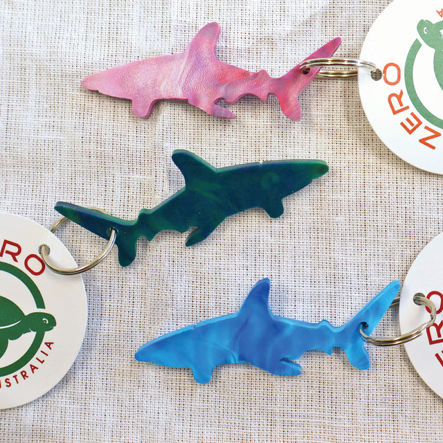 Purple, blue and green shark shaped keyrings made with recycled plastic milk bottle lids.