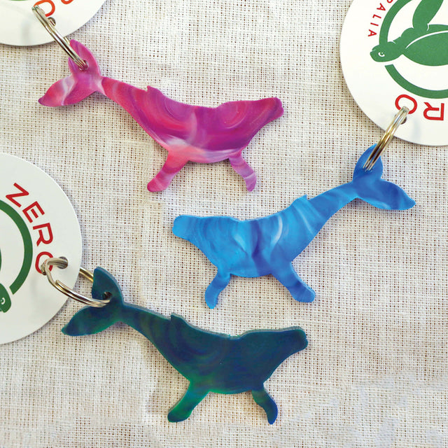Purple, blue and green humpback whale shaped keyrings made with recycled plastic milk bottle lids.