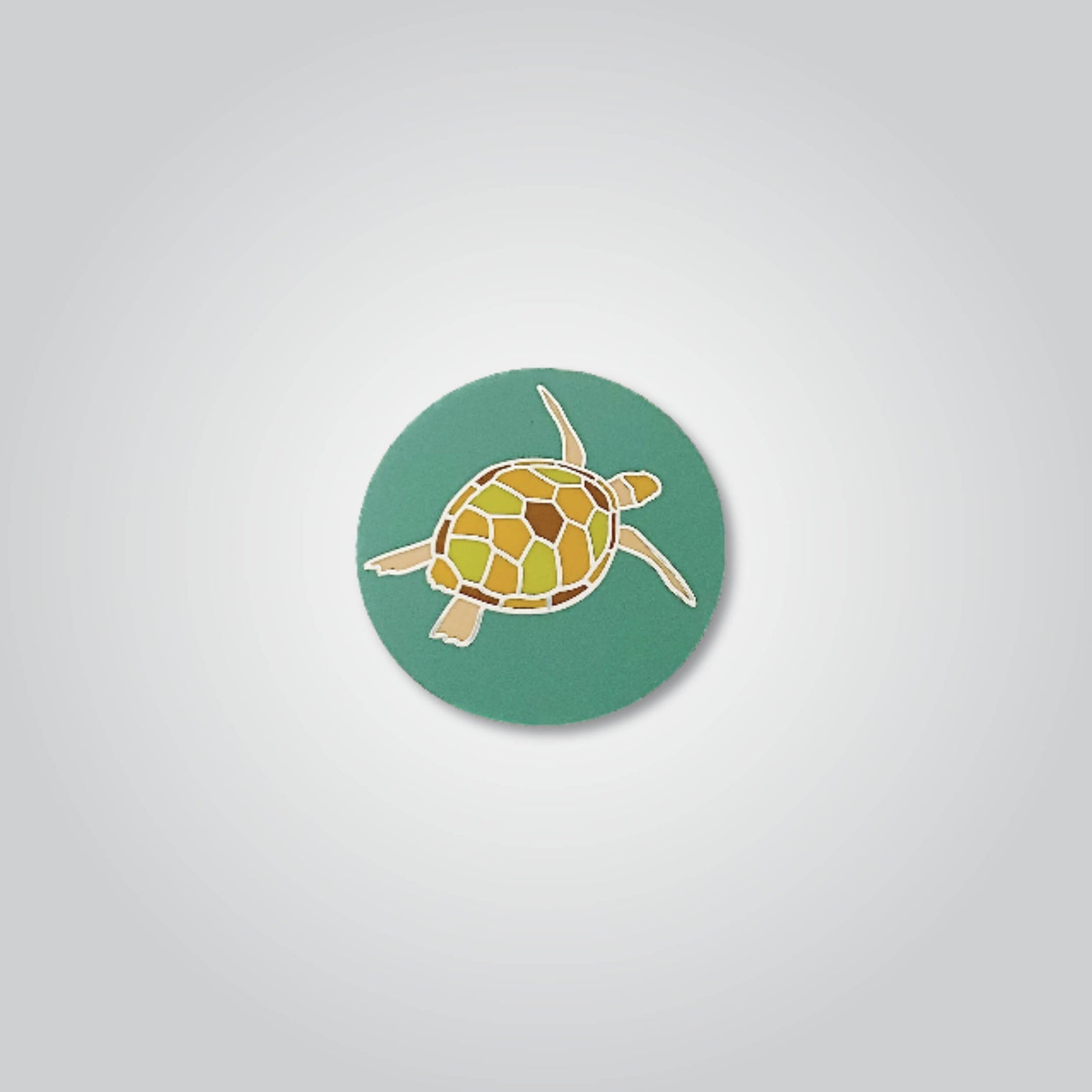 Lapel pin of a green sea turtle by Red Parka. 
