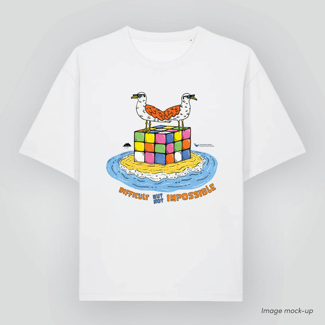 Mock-up image of the 'Nature is for everyone' t-shirt (front) in organic cotton with a print of Mulga the Artist's artwork of two seabirds, 'Marty and Geoff the Seagulls', standing on a Rubik's Cube and text underneath 'Difficult but not impossible'.